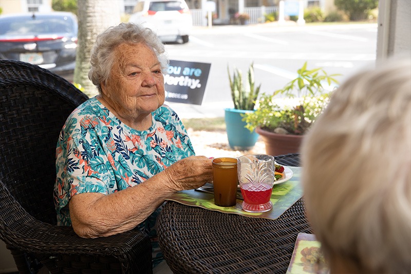 elderly female resident enjoying breakfast at our assisted living facility